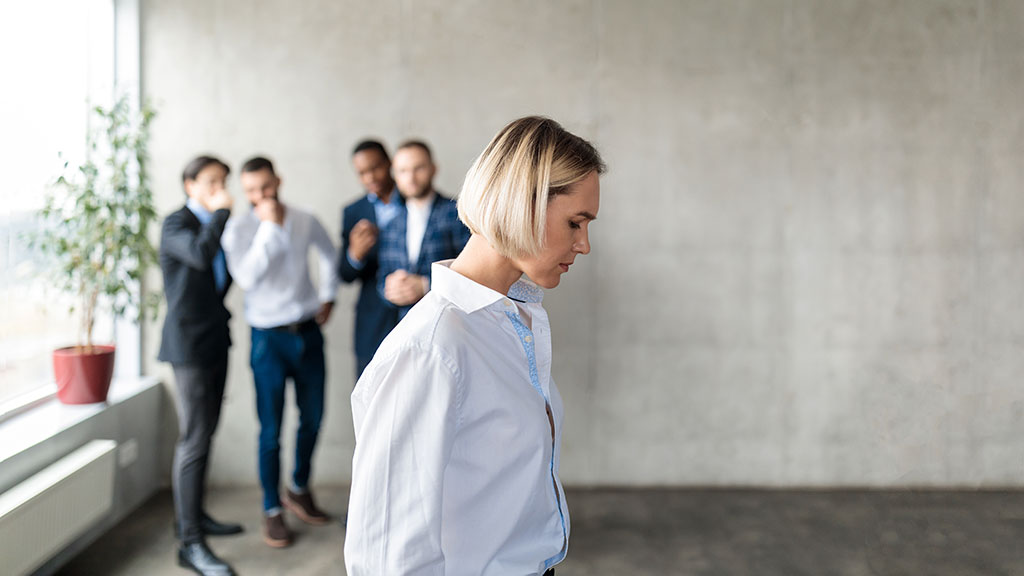 Workplace Bullying And Sexism. Male Colleagues Whispering Behind Back Of Unhappy Business Lady In Office. Victimization At Work. Female Discrimination Corporate Problem. Selective Focus, Panorama