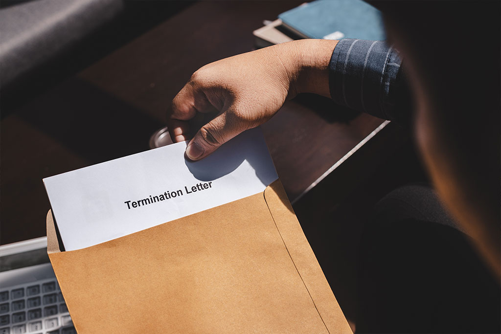 tressed businessman feeling down after received Termination of Employment Form in paper brown envelope